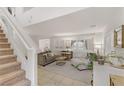 Bright living room with a staircase, neutral-toned furniture, tile floors, and plantation shutters for privacy at 10899 Royal Highlands St, Las Vegas, NV 89141