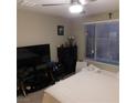 Bright bedroom with a ceiling fan, large television, and black dresser at 10976 Bluebell Basin Rd, Las Vegas, NV 89179