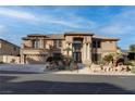 Two-story tan home featuring a front-facing two car garage and well-manicured front yard at 1534 Waterford Falls Ave, Las Vegas, NV 89123