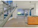 Open living room with industrial staircase, floor-to-ceiling windows, and island kitchen at 360 E Desert Inn Rd # 602, Las Vegas, NV 89109