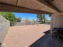 This image shows a covered patio overlooking a spacious backyard with gravel and block wall fencing at 4312 Alpine Pl, Las Vegas, NV 89107