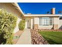 Close up of the home's front entrance and picture window, surrounded by rock landscaping at 4666 Amberwood Ln, Las Vegas, NV 89147