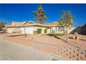 Single-story home featuring a xeriscaped front yard, white garage door and mature trees at 4666 Amberwood Ln, Las Vegas, NV 89147