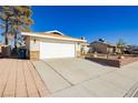 View of the two-car garage and paved driveway of this single Gathering home at 4666 Amberwood Ln, Las Vegas, NV 89147