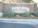 Entrance to South Encantada, showcasing stacked stone signage and desert landscaping including agave and cacti at 5490 Floating Flower Ave, Las Vegas, NV 89139