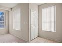 Bright entryway with tile floor, white door, and natural light from two windows at 701 Aztec Cir, Mesquite, NV 89027