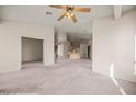 Open living area with neutral carpet and paint, ceiling fan, and access to kitchen at 701 Aztec Cir, Mesquite, NV 89027