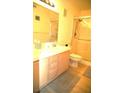 Well-lit bathroom featuring double sinks, tile countertops, and a glass-enclosed shower at 7950 W Flamingo Rd # 1139, Las Vegas, NV 89147