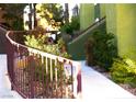 Landscaped walkway with a decorative burgundy-colored metal railing and plants at 7950 W Flamingo Rd # 1139, Las Vegas, NV 89147