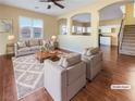 Bright living room with a ceiling fan, a large window, and views into the kitchen at 8452 Viansa Loma Ave, Las Vegas, NV 89149