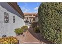 Inviting walkway leading to front door framed by mature hedges, and a textured stucco wall at 10708 Clear Meadows Dr, Las Vegas, NV 89134