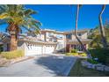 Gorgeous two-story home featuring a three-car garage, manicured landscaping, and mature palm trees at 204 N Ring Dove Dr, Las Vegas, NV 89144
