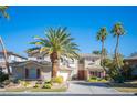 Beautiful two-story home boasting a three-car garage, desert landscaping, and swaying palm trees at 204 N Ring Dove Dr, Las Vegas, NV 89144