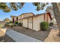 Exterior side view of a townhouse unit surrounded by meticulous landscaping and featuring a brick accent wall at 2333 Wooster Cir # B, Las Vegas, NV 89108