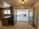 Kitchen featuring tile floors and granite countertops with open doors to a sunroom at 2451 Muirfield Ave, Henderson, NV 89074