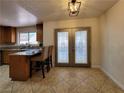 Eat-in kitchen boasts an island with bar seating, double doors, and attractive light fixture at 2451 Muirfield Ave, Henderson, NV 89074