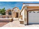 Close up view of stucco home's front exterior showcasing a two-car garage and stone accents along the front at 3665 S Pointe Cir, Laughlin, NV 89029