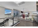 A hallway with glass railings and a view of the living room below at 43 Grey Feather Dr, Las Vegas, NV 89135