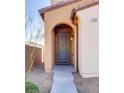 Covered entryway with stone walkway, dark gray door, and exterior lighting at 7203 Pepperbox Ave, Las Vegas, NV 89179