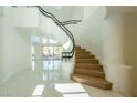 Elegant entryway featuring a curved staircase, modern railings and marble flooring at 8208 Horseshoe Bend Ln, Las Vegas, NV 89113