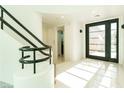 Bright foyer with sleek black front door, modern lighting, and polished marble floors at 8208 Horseshoe Bend Ln, Las Vegas, NV 89113