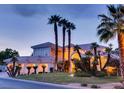 A luxurious estate showcasing mature palm trees, lush landscaping and a circular driveway leading to the grand entrance at 10 Innisbrook Ave, Las Vegas, NV 89113