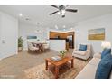 Bright living room featuring neutral furniture, tile flooring, and an open layout to the kitchen at 11428 Belmont Lake Dr # 104, Las Vegas, NV 89135