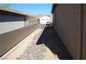 Narrow side yard with decorative rock landscaping and a privacy fence at 2601 Centaurus St, Henderson, NV 89044