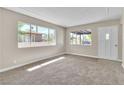 Bright and airy living room featuring large windows, plush carpeting, and a freshly painted interior at 2716 Salt Lake St, North Las Vegas, NV 89030