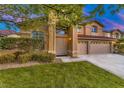Beautiful two-story home featuring a well-maintained lawn and lush landscaping at 283 Auster Park Ave, Las Vegas, NV 89148