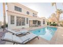 Inviting backyard with a sparkling pool, lounge chairs, and a table with chairs at 299 Francisco St, Henderson, NV 89014