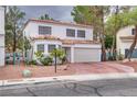 Charming home featuring a neutral stucco facade, red tile roof, meticulously maintained front yard, and an attached two-car garage at 3491 Bankside Dr, Las Vegas, NV 89129