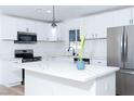 Close-up of a contemporary kitchen featuring white cabinets, quartz countertops, and stainless appliances at 4818 E Monroe Ave, Las Vegas, NV 89110