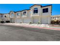 Exterior of the townhome featuring attached garages, street view, and well-maintained curb appeal at 4821 Black Bear Rd # 101, Las Vegas, NV 89149