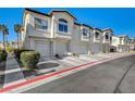 Exterior of the townhome featuring attached garages, street view, and well-maintained curb appeal at 4821 Black Bear Rd # 101, Las Vegas, NV 89149