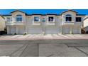 Exterior of the townhome featuring attached garages, street view, and well-maintained curb appeal at 4821 Black Bear Rd # 101, Las Vegas, NV 89149