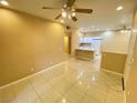 Spacious open floorplan, tile floor, ceiling fan, and kitchen view at 5751 E Hacienda Ave # 130, Las Vegas, NV 89122