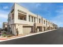 Modern beige townhouse exteriors with two-car garages, minimal landscaping, and paved street at 600 N Carriage Hill Dr # 2098, Las Vegas, NV 89138