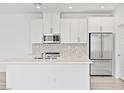 Bright, white kitchen with stainless steel appliances and a center island with quartz countertop at 600 N Carriage Hill Dr # 2098, Las Vegas, NV 89138