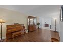 Bright living area with wood floors, featuring a piano, china cabinet, and seamless flow into adjacent spaces at 645 Paloma Dr, Boulder City, NV 89005