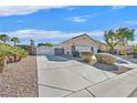 Exterior shot of the home's long driveway with desert landscaping and mature trees at 6710 Pyracantha Glen Ct, Las Vegas, NV 89131