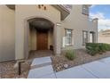 Inviting front entrance with an arched entryway and a solid wood door at 73 Lomita Heights Dr, Las Vegas, NV 89138