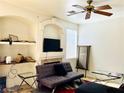Cozy living room featuring tile flooring, ceiling fan and shelving at 8209 Violet Meadow Ct, Las Vegas, NV 89117