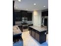 Well-lit kitchen with stainless steel appliances, granite countertops, and dark cabinets at 9138 Sea Mink Ave, Las Vegas, NV 89149