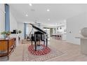 Open living area with tile floors, a grand piano, and access to the kitchen and dining area at 12125 Arrebol Ave, Las Vegas, NV 89138