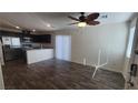 Open-concept living room featuring wood floors, modern lighting, and access to the kitchen and outdoor spaces at 2734 Champagne Gold Ave, North Las Vegas, NV 89086