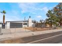 Charming single-story home featuring a modern gray garage door, white chimney, and well-kept front yard at 348 Upland Blvd, Las Vegas, NV 89107