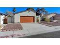 Quaint single-story home featuring a red garage door, a covered front porch, and low-maintenance landscaping at 4768 W Montara Cir, Las Vegas, NV 89121