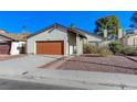 A cozy single-story home featuring a red garage door and a well-kept front yard at 4768 W Montara Cir, Las Vegas, NV 89121