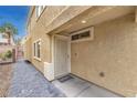 Side entrance with a secure screen door, brick pathway and stucco exterior at 4787 Essen Ct, Las Vegas, NV 89147